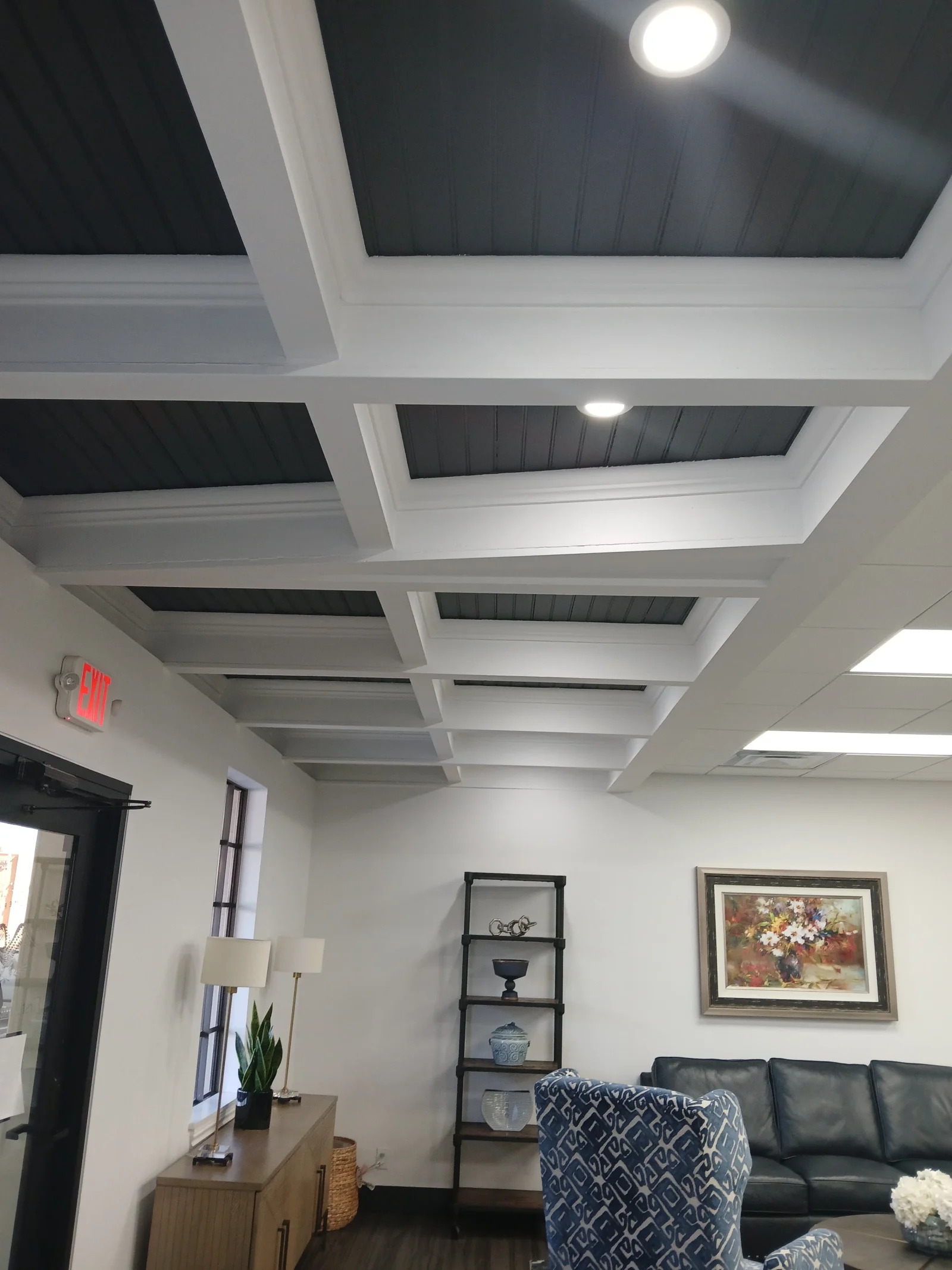 White coffered ceiling with dark gray panels and recessed LED lighting in living room