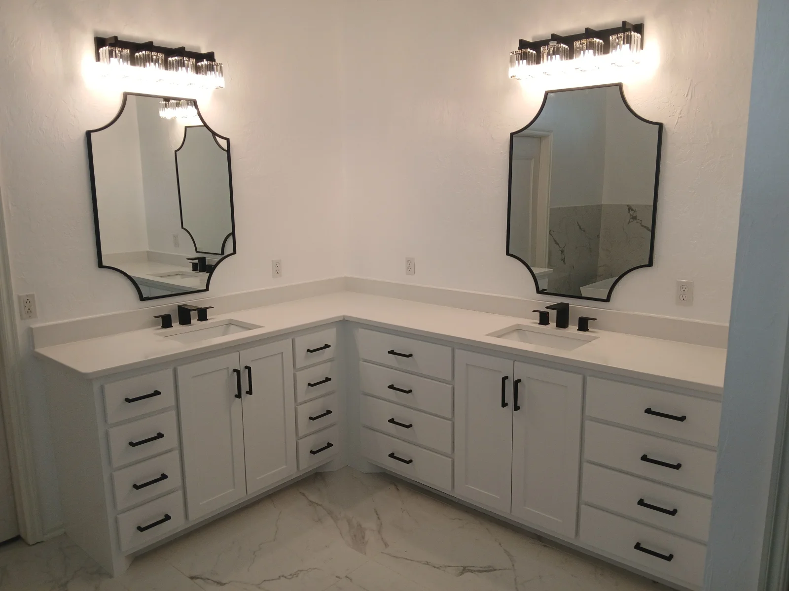 Dual white vanity with quartz countertop, black hardware, framed mirrors, and pendant lighting in master bathroom