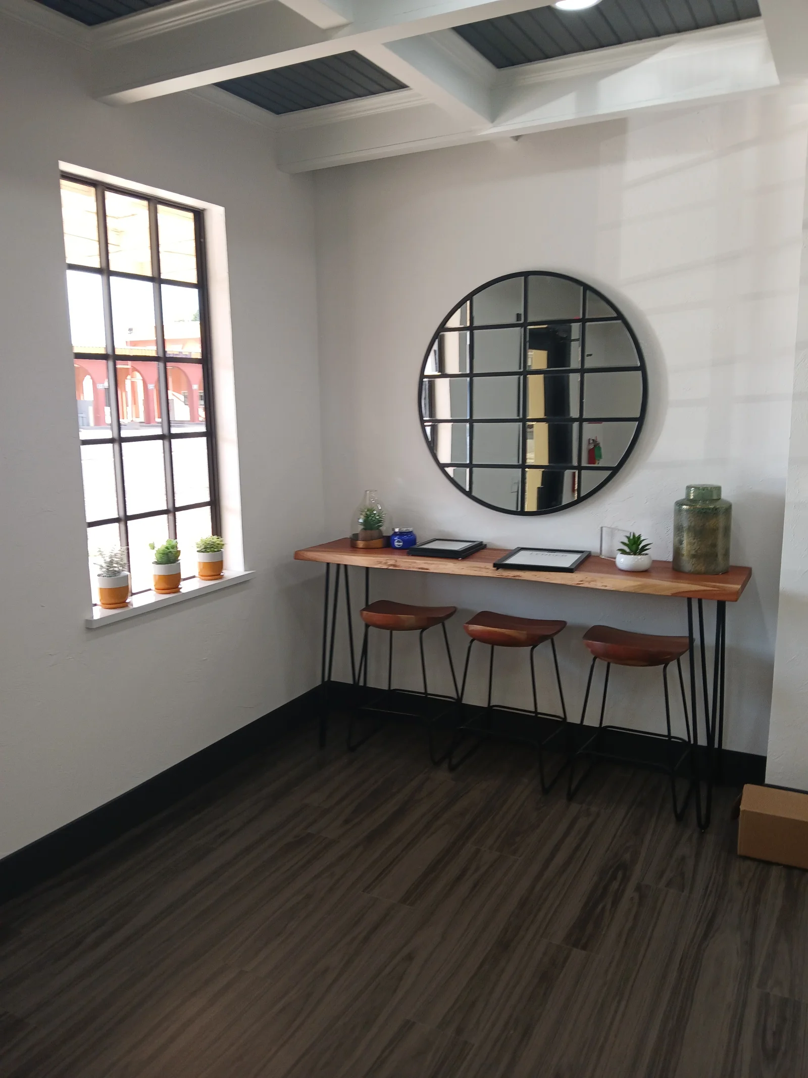 Modern office nook with vinyl plank flooring, white walls, wood desk, and recessed ceiling lighting